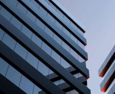 The two modern buildings with glass windows. Architecture design of buildings. Office space, houses at sunset in the evening. 3D render.