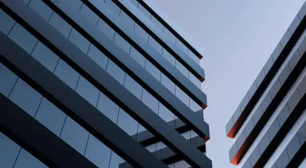 architecting-agility-business-growth The two modern buildings with glass windows. Architecture design of buildings. Office space, houses at sunset in the evening. 3D render.